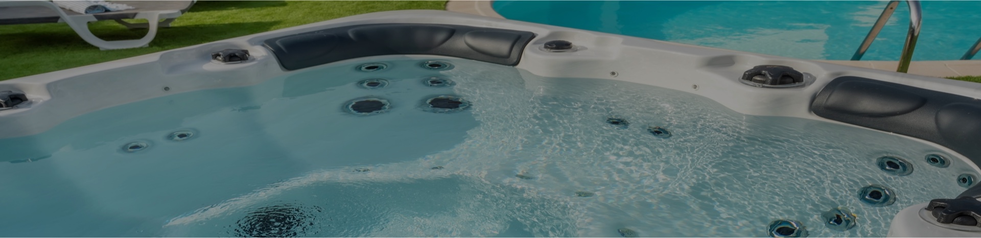 Outdoor spa filled with clear water, with jets running and headrests, ready for use after its seasonal opening.
