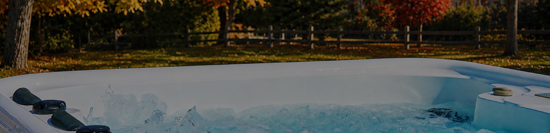Outdoor spa with bubbling jets in a garden filled with autumn colours, before being closed and prepared for winter.