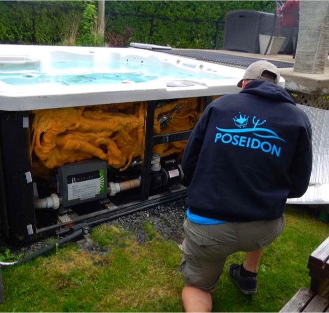 Poseidon technician inspecting the components and plumbing of an outdoor spa during an opening and maintenance service.