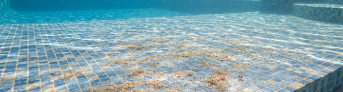 Sand deposits at the bottom of a pool, a sign of a worn-out filter that needs changing