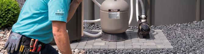 POSEIDON technician beside an outdoor filtration system for pool pump maintenance or repair.
